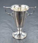 A George VI silver footed vase, of fluted form having two scroll handles and slight planished finish