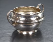 An early 20th century silver sugar bowl, of rounded form having two C scroll handles and step