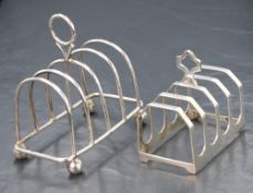 Two early 20th century silver toast racks, one of rounded form having four ball feet, the other of