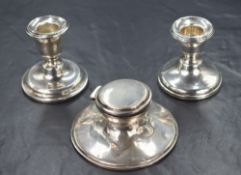 A pair of George V silver stout candlesticks, of traditional form having step moulded sconces, one