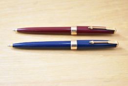 Two Parker 17 Super Duofold ballpoint pens in blue, red with gold trim