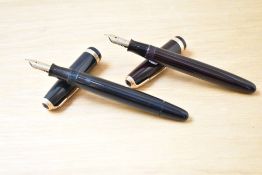 Two Parker Duofold button fill fountain pens one in dark brown the other black with Duofold broad