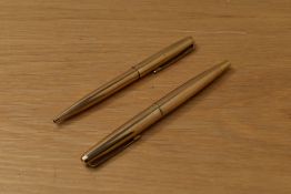 A Parker 45 Insignia CT converter fill fountain pen and ballpoint pen in gold fill with gold tassie