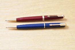Two Parker Duofold propelling pencils one red with broad cap band one blue with narrow cap band