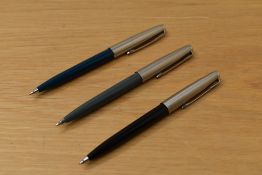 Three Parker 45 ballpoint pens in grey, teal and black