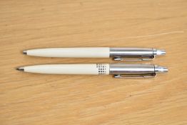 Two Parker Jotter ballpoint pens in ivory (one with a calendar print)