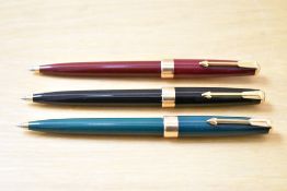 Three Parker 17 Super Duofold ballpoint pens in black, red, and green.
