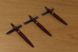 Three Parker 45 converter fill fountain pens in burgundy with lustraloy caps. One engraved