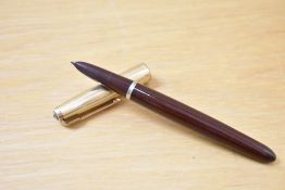 A Parker 51 plunger fill fountain pen in burgundy with rolled gold cap. Slight wear to rim of cap.