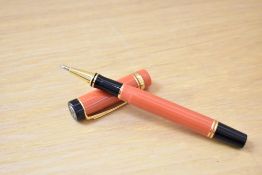 A Parker Centennial Special Edition rollerball pen in orange with one broad and one narrow cap