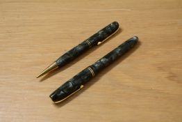 A boxed Burnham lever fill fountain pen and propelling pencil set in green marble with two narrow