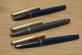 Three Parker fountain pens a grey 51 with rolled gold cap, a Mark IIIV Parker 51 in green with