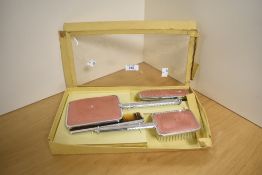 A vintage ladies four piece dressing table set with inlaid pink design.