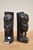 A pair of African carved hardwood bookends, modelled as warrior heads, each measuring 20cm high