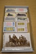 A selection of vintage postcards featuring photographic prints of military interest, and a small