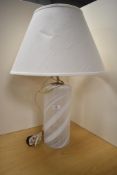 An attractive glass table lamp, of cylindrical form and decorated with white opaque swirls, 33cm