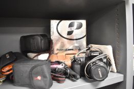 A Canon EOS 1000F DSLR camera, together with a selection of other cameras and binoculars