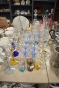 An assortment of vintage coloured glasses including wine glasses, sundae glasses and a serving jug