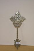 An Ethiopian Orthodox Christian white metal processional cross, of pierced design with engraved