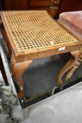 An early 20th Century Queen Anne style dressing table stool having canework seat