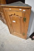 A natural pine corner cupboard