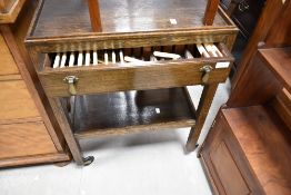 An early 20th Century oak tea trolley having integral cutlery canteen