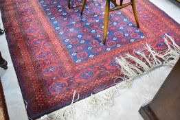 A traditional Persian rug having red ground with blue pattern, approx.266 x 155cm