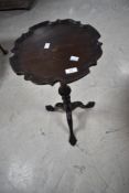 A 1920s piecrust tripod table having ball and claw feet
