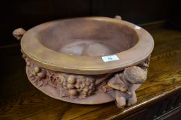 A reproduction resin clay style planter holder having cherub design