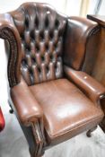 A brown leather wingback armchair