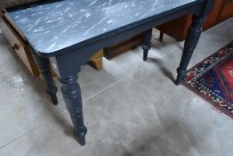 A vintage kitchen table having Victorian turned base, with later paint including marble effect