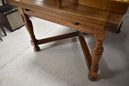 An early 20th Century oak drawer leaf dining table and set of six ladder back dining chairs of