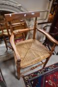 A Victorian country style railback carver chair having rush seat and turned frame