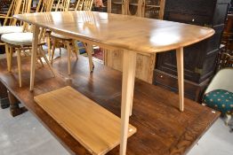 A light stain Ercol extending dining table on typical splay legs, approx. 153 x 91cm, plus