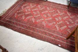 A traditional Persian rug in maroon ground with brown and cream pattern, approx. 230 x 150cm