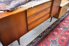 A vintage teak sideboard having three central drawers, flanked by cupboards, width approx. 179cm