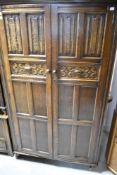 A vintage oak wardrobe and bedside cabinet, having linen fold decoration
