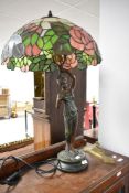 A vintage figural bronze effect table lamp with tiffany style shade