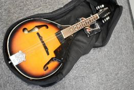 A Fender FM-100 electric mandolin, in padded gig bag, with spare strings, scratch plate loose