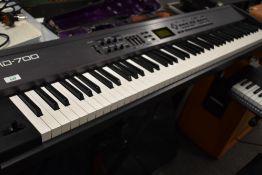 A Roland RD-700 keyboard, with folding stand, power supply, foot pedal and padded gig bag, in nice