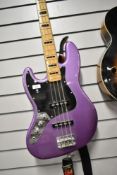 A Fender Squier Jazz Bass, Left Handed in Purple, with padded gig bag