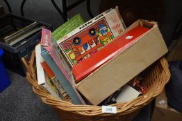 A vintage wicker basket with matching lid filled with a selection of assorted small childrens