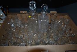 A carton of assorted vintage etched and plain spirit glasses and two cut glass decanters, one AF.