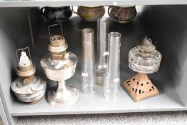 A Victorian cast iron oil lamp, with clear glass shade, sold together with two other oil lamps and