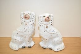 A pair of Victorian Staffordshire pottery dogs, the detail heightened with gilding and each
