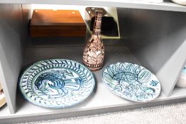 Two large 20th century Spanish terracotta plates, vibrantly hand coloured with exotic bird and