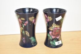 A pair of Royal Stanley Jacobean ware vases, decorated with anemore flowers upon a blue