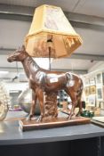 A 20th century equestrian ceramic table lamp with a mustard frilled shade depicting a hunting scene,