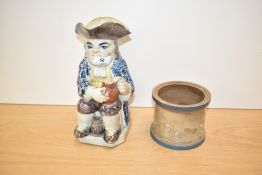 A large 19th century Toby jug of a gentleman seated using both hands to steady his brew, 25cm,