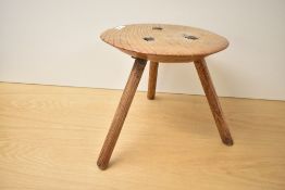 A 19th century primitive elm tripod milking stool, h24cm.
